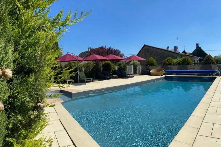 Vue large de la piscine avec parasols rouges