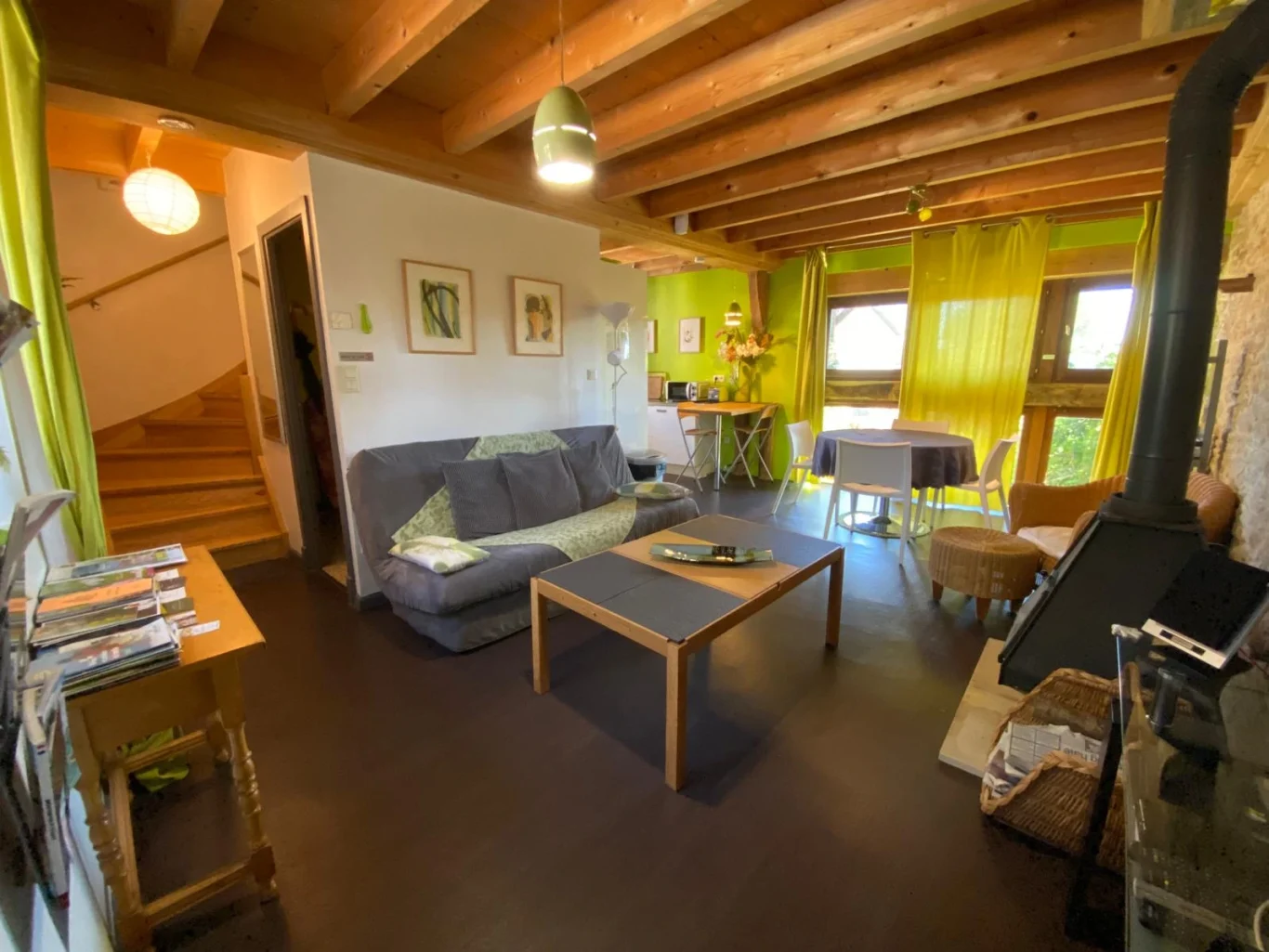 Salon avec poêle à bois et mur en pierre apparente montée vers l'étage Salon avec poêle à bois et mur en pierre apparente montée vers l'étage