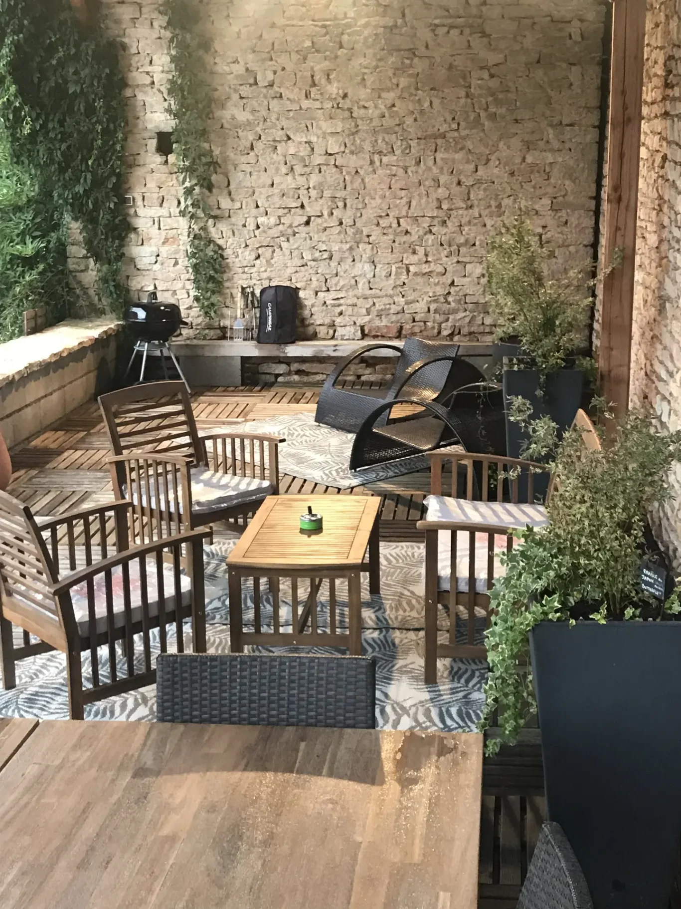 Terrasse aménagée en salle à manger avec fauteuils en rotin Terrasse aménagée en salle à manger avec fauteuils en rotin